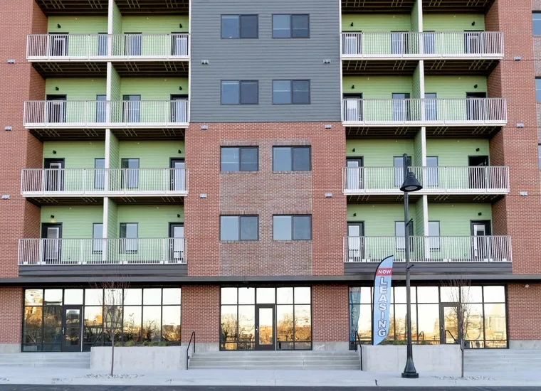 Newly built mixed-use apartment building with ground-floor retail storefronts